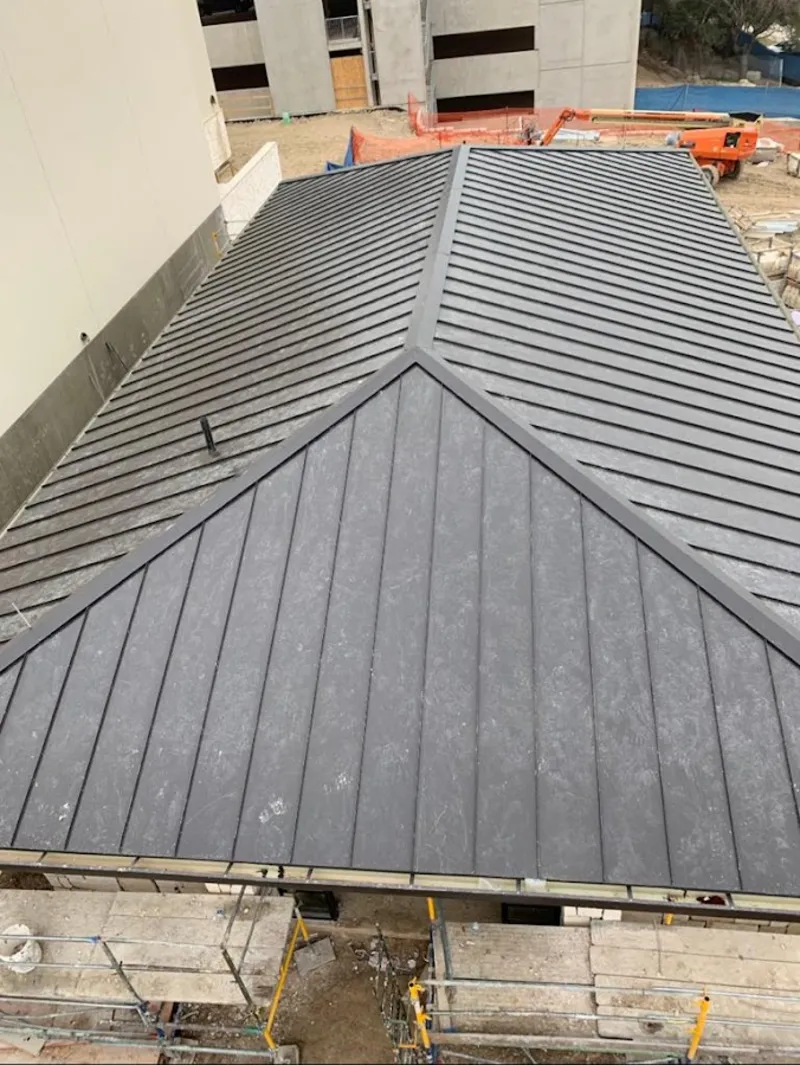 Commercial metal roof construction with crane equipment in Webster